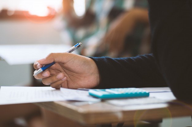close-up-students-writing-reading-exam-answer-sheets-exercises-classroom-school-with-stress_73622-889